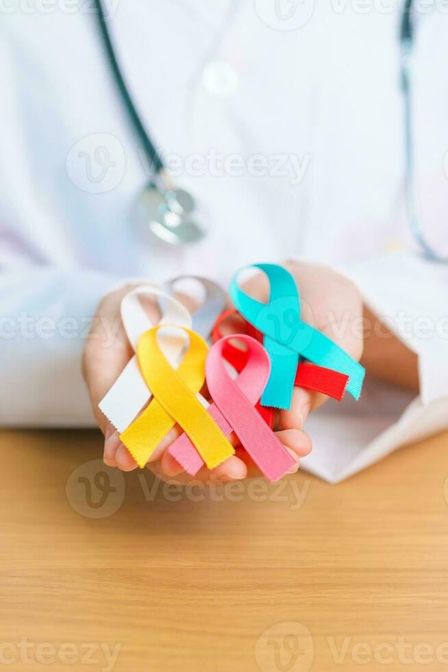 World cancer day, February 4. Doctor hold colorful ribbons, blue, yellow, red, green, white, pink and grey for supporting people living and illness. Health, Medical, awareness and Insurance concept photo
