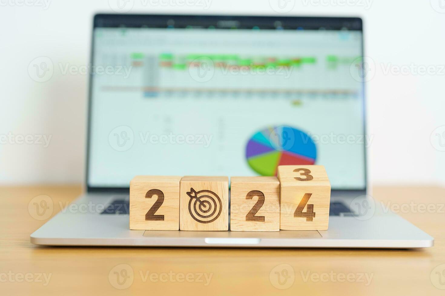 2024 Year block with dartboard icon against computer laptop background. Goal, Target, Resolution, strategy, plan, Action, mission, motivation, and New Year start concepts photo