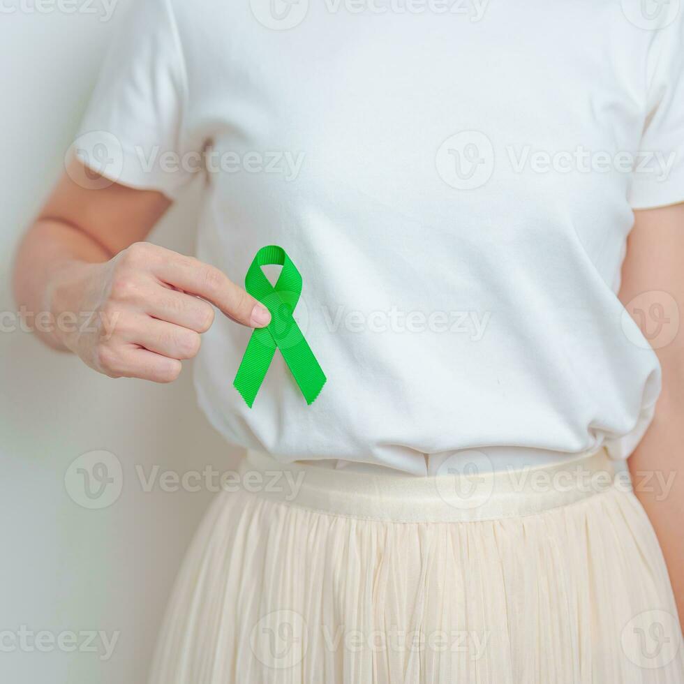 Woman having liver pain with green ribbon. Liver Cancer October awareness month, Tumor, Jaundice, Virus Hepatitis, Cirrhosis, Failure, Enlarged, Hepatic Encephalopathy, and health concept photo