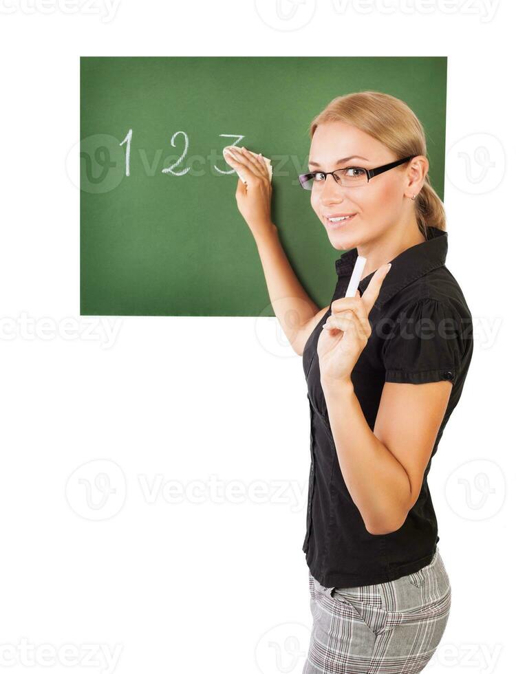 Teacher writting on chalkboard photo