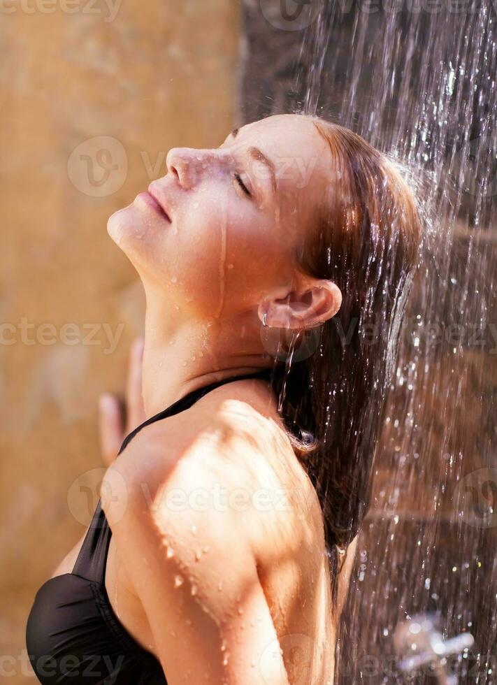 mujer debajo refrescante frío ducha foto