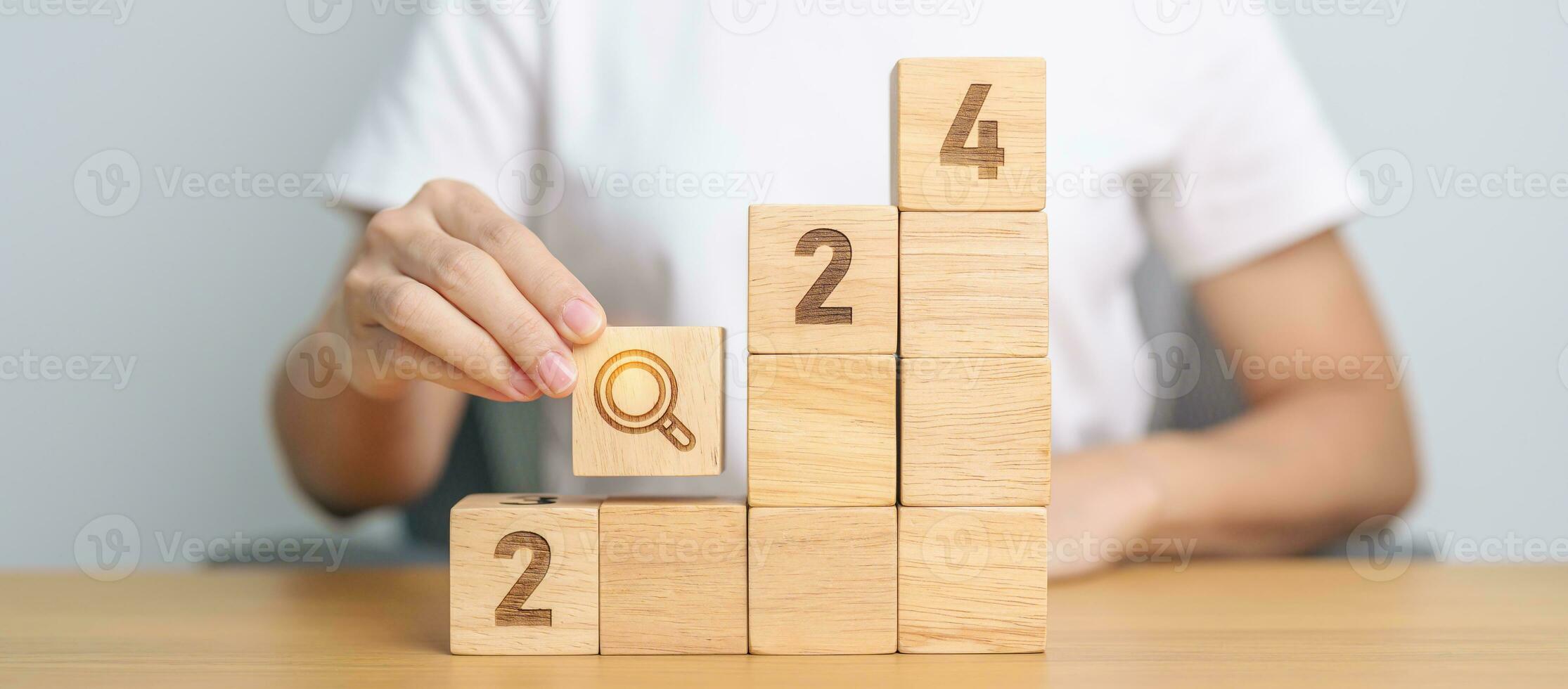 hand holding 2024 block with magnifying glass icon. SEO, Search Engine Optimization, hiring , Advertising, Idea, Strategy, marketing, Keyword, Content and New Year start concepts photo
