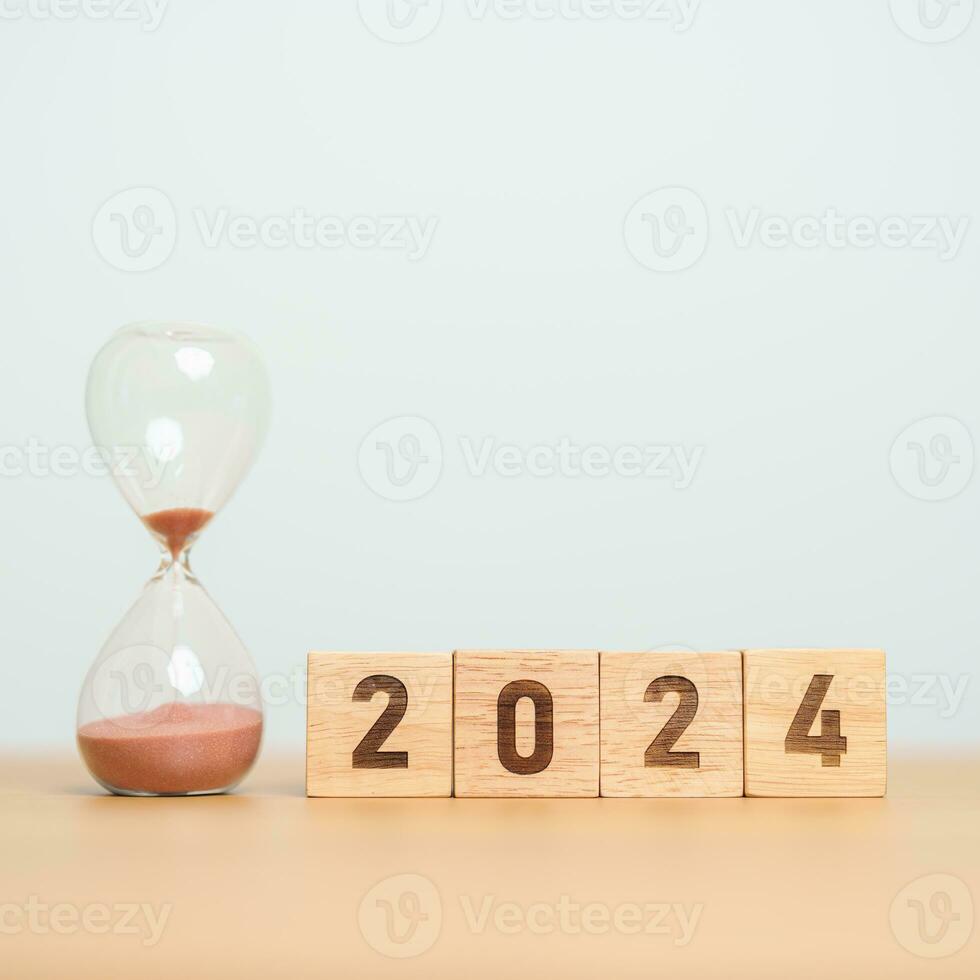 2024 texto con reloj de arena en mesa. resolución, tiempo, plan, meta, motivación, reiniciar, cuenta regresiva y nuevo año fiesta conceptos foto