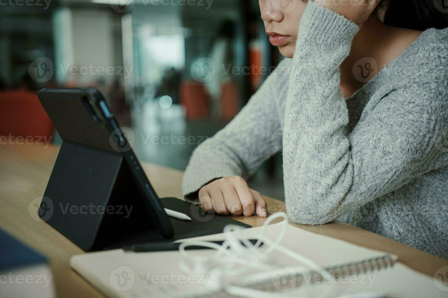 asiático estudiante mujer leer libros en biblioteca a universidad. joven niña estrés cansado tener problema mientras estudiar duro. tristeza concepto foto