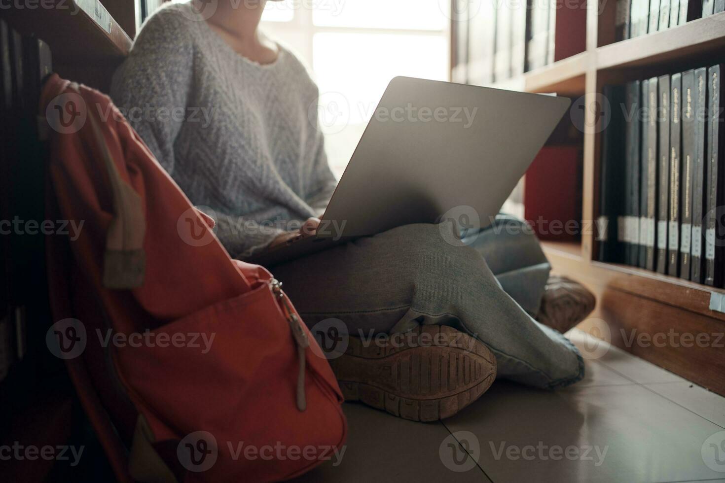 Student girl sitting on floor and using laptop, Writes notes for paper, Essay, Study for class assignment. Diverse group of Students Learning, Studying for Exams. photo