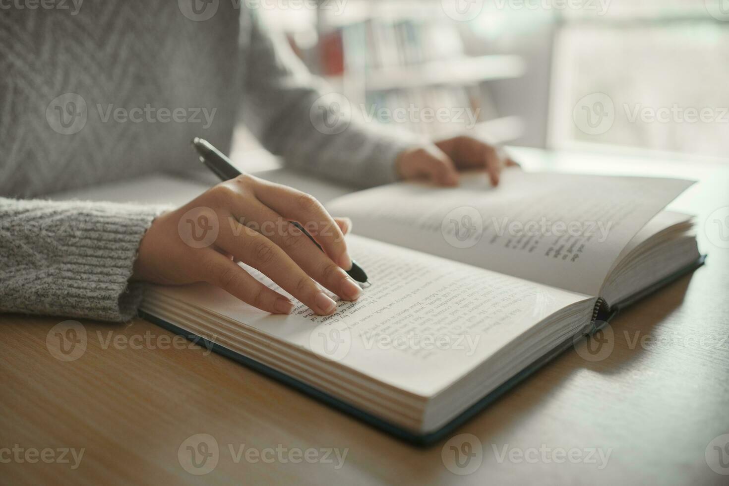 Student preparing for college test, exam, reading book, studying textbook, writing notes, making summary for class report. Learning workplace table, hands with pencil close up photo