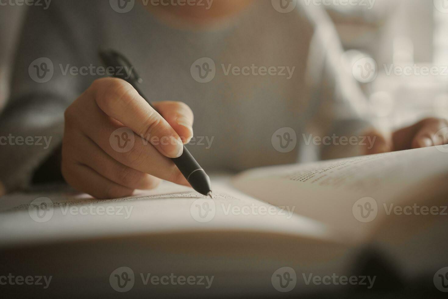 Student preparing for college test, exam, reading book, studying textbook, writing notes, making summary for class report. Learning workplace table, hands with pencil close up photo