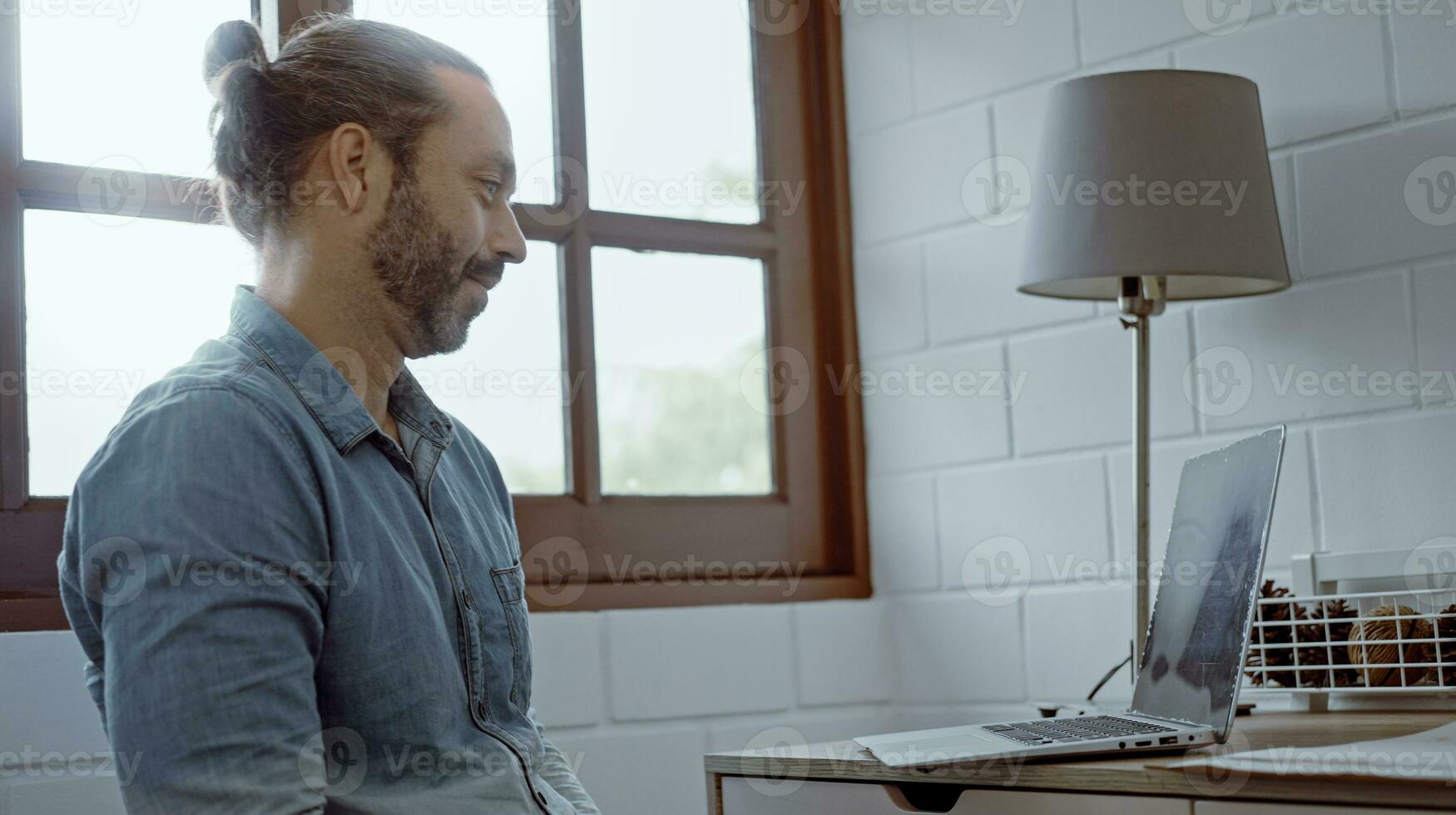 Young worried man using laptop sitting on the desk. photo