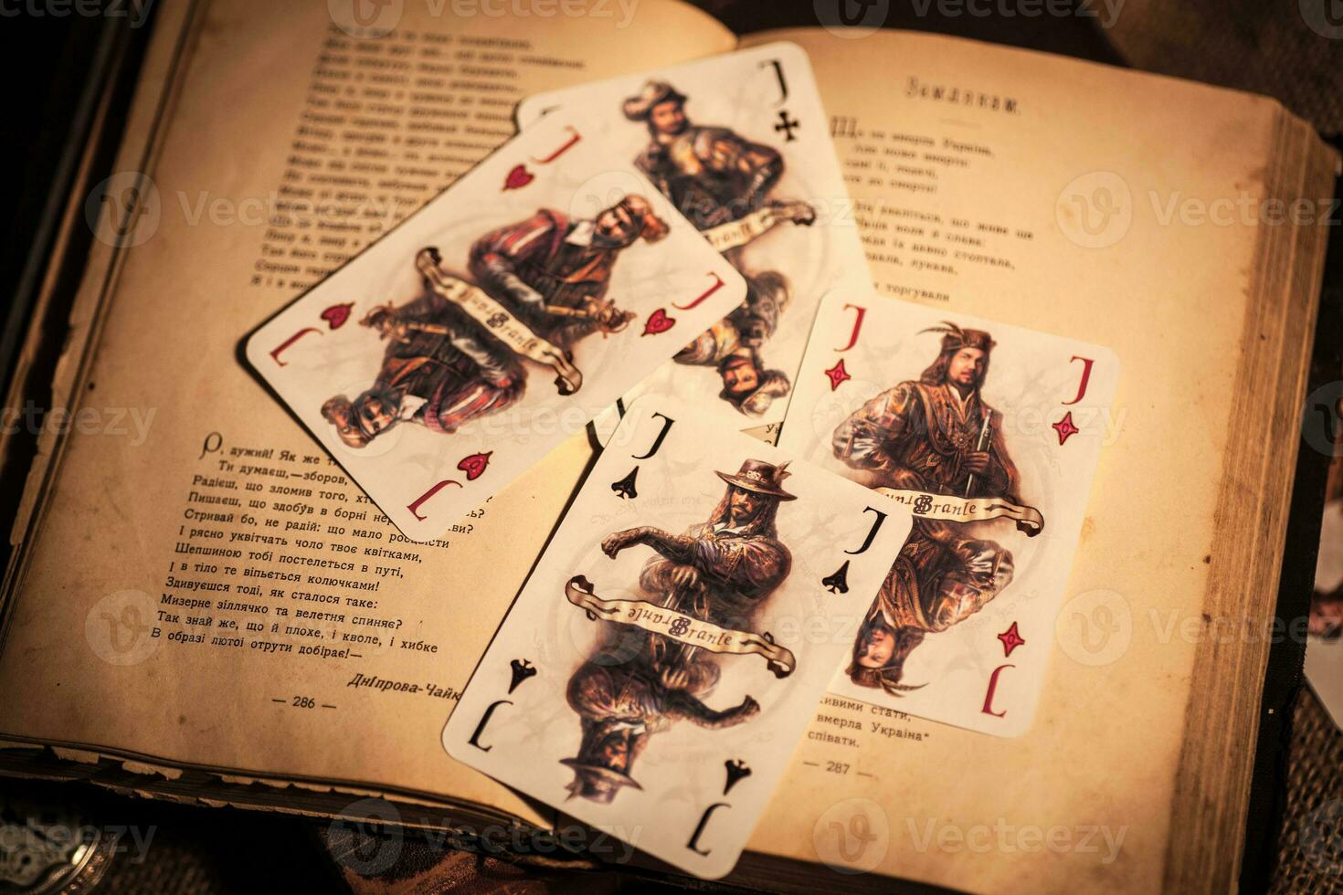 a still life of four playing cards on burlap and a beautiful still life with old books and a clock photo