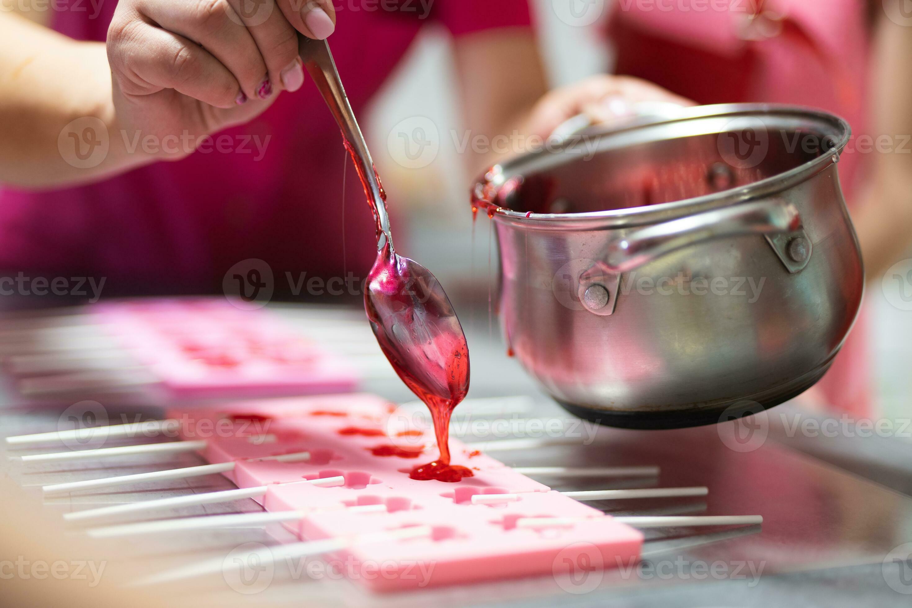process of making delicious lollipops by pouring them into molds