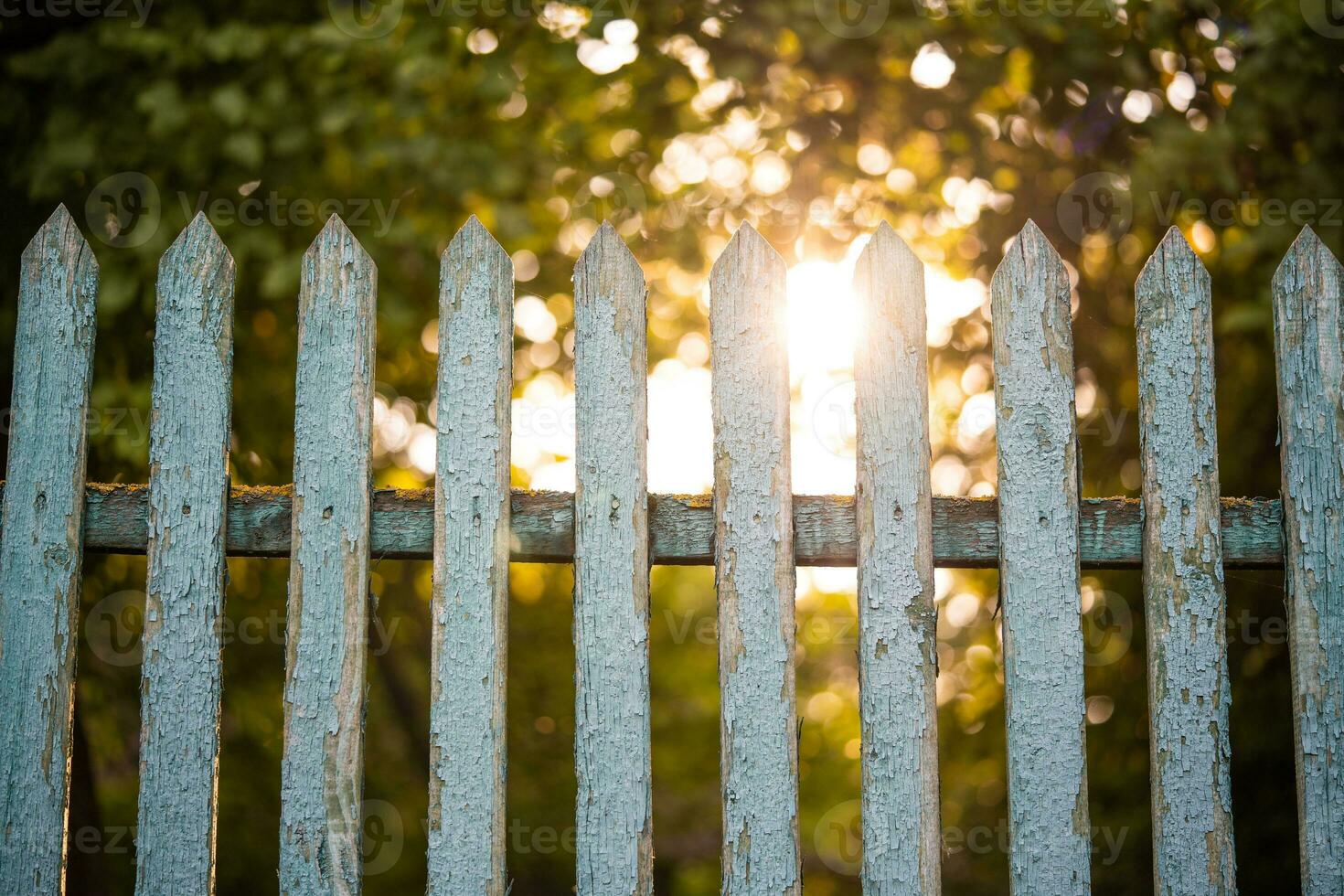 beautiful wooden fence in the village in the contrast sunlight photo
