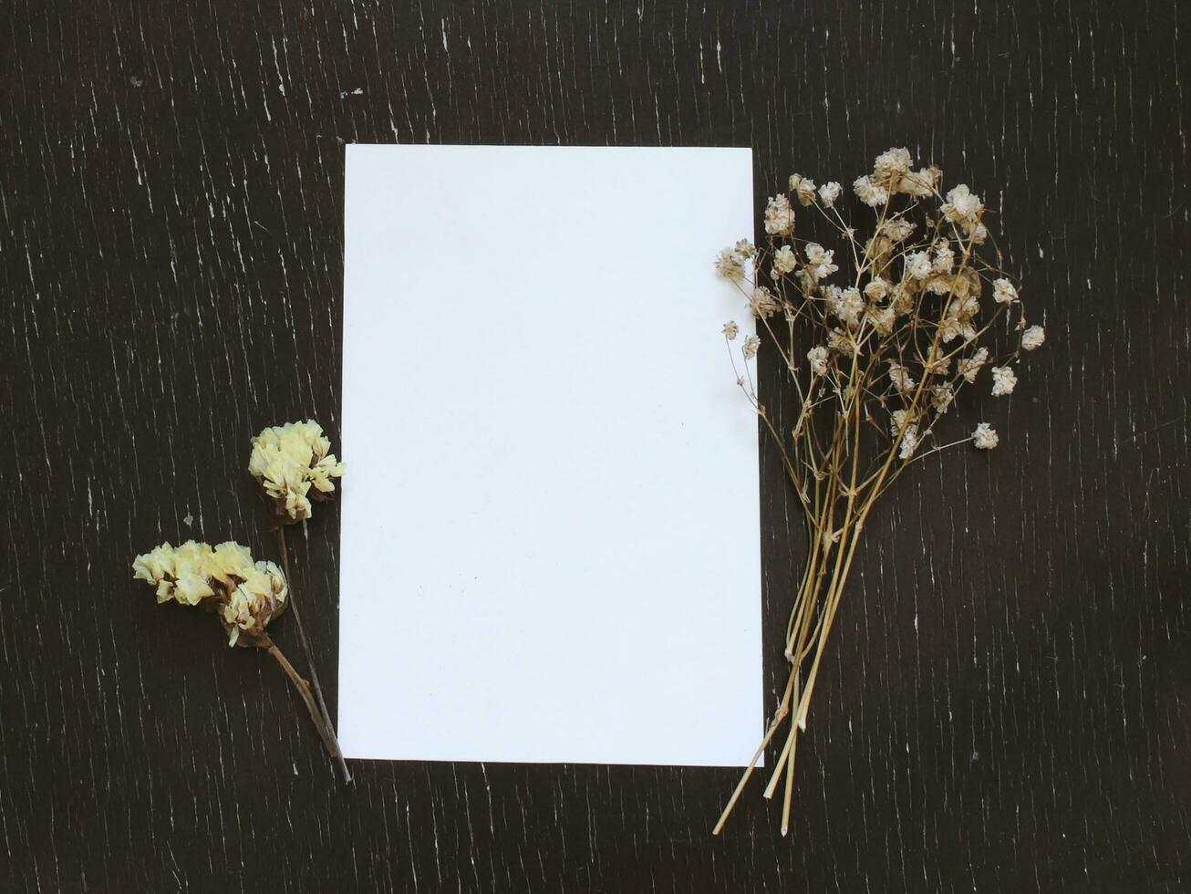 Blank greeting card with flower on rustic wood background for creative work design photo