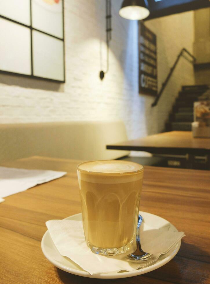 taza de caliente latté en mesa en el café foto