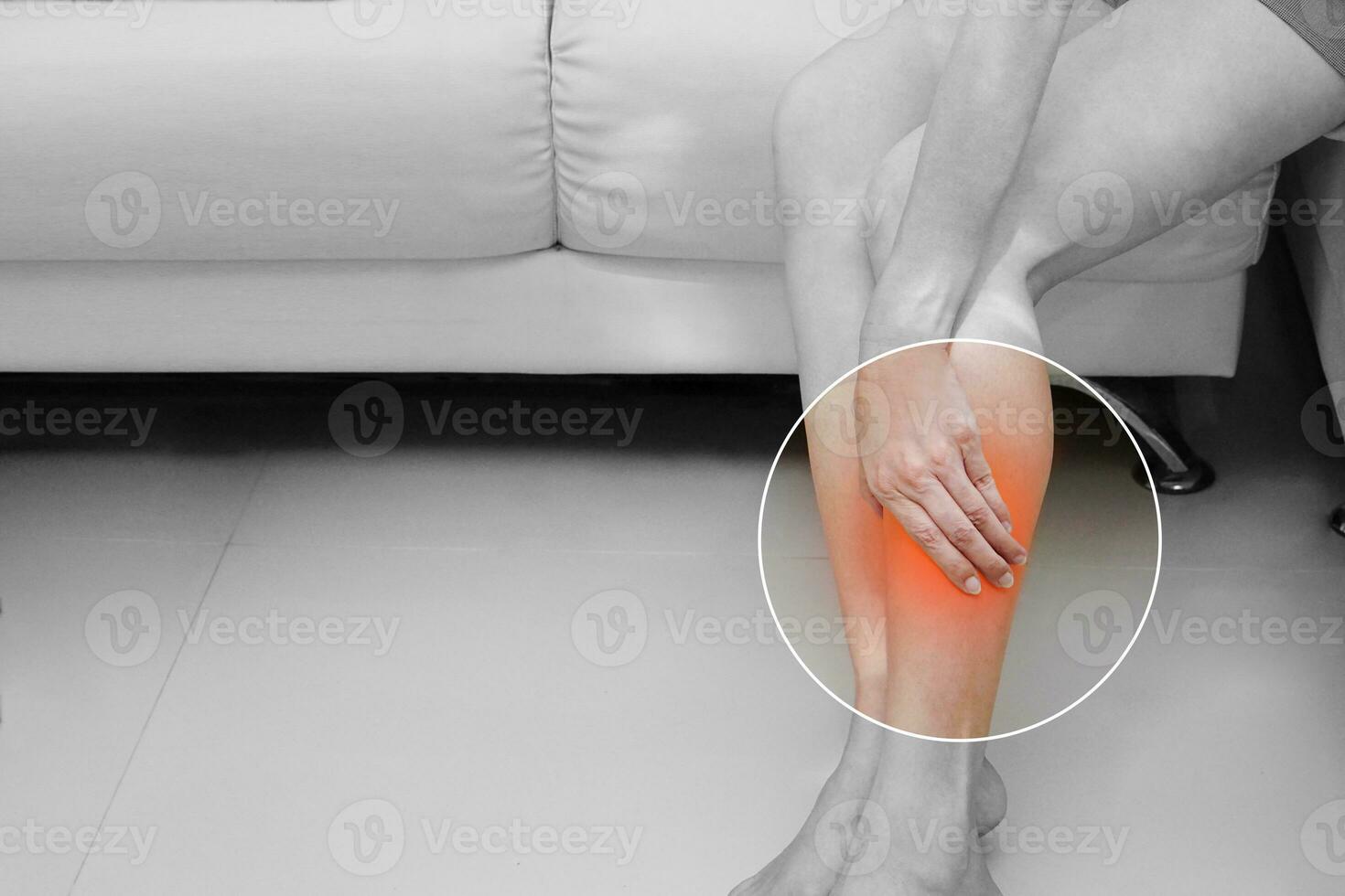Black and white photo of woman, She shows suffering from leg pain. Medical and health concept.