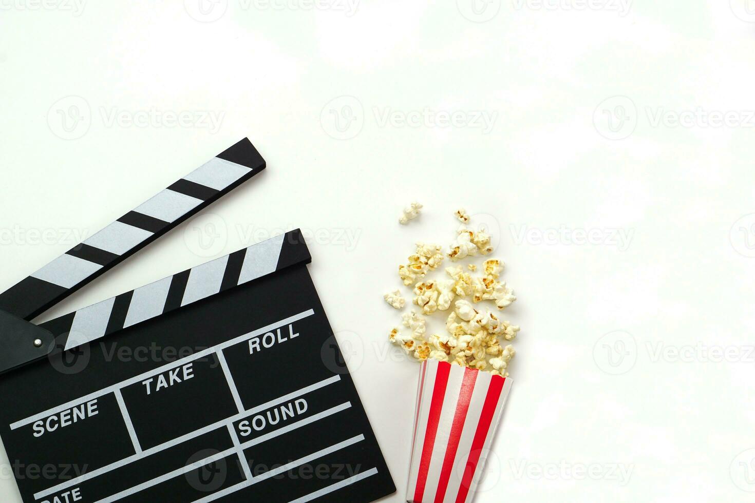 Clapperboard or movie slate black color with popcorn on white background. Cinema industry, video production and film concept. photo