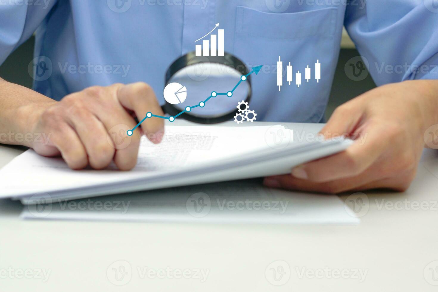 Hand of businessman with magnifying glass analyzing graphs and charts. Investment data, sales information and data validation. photo