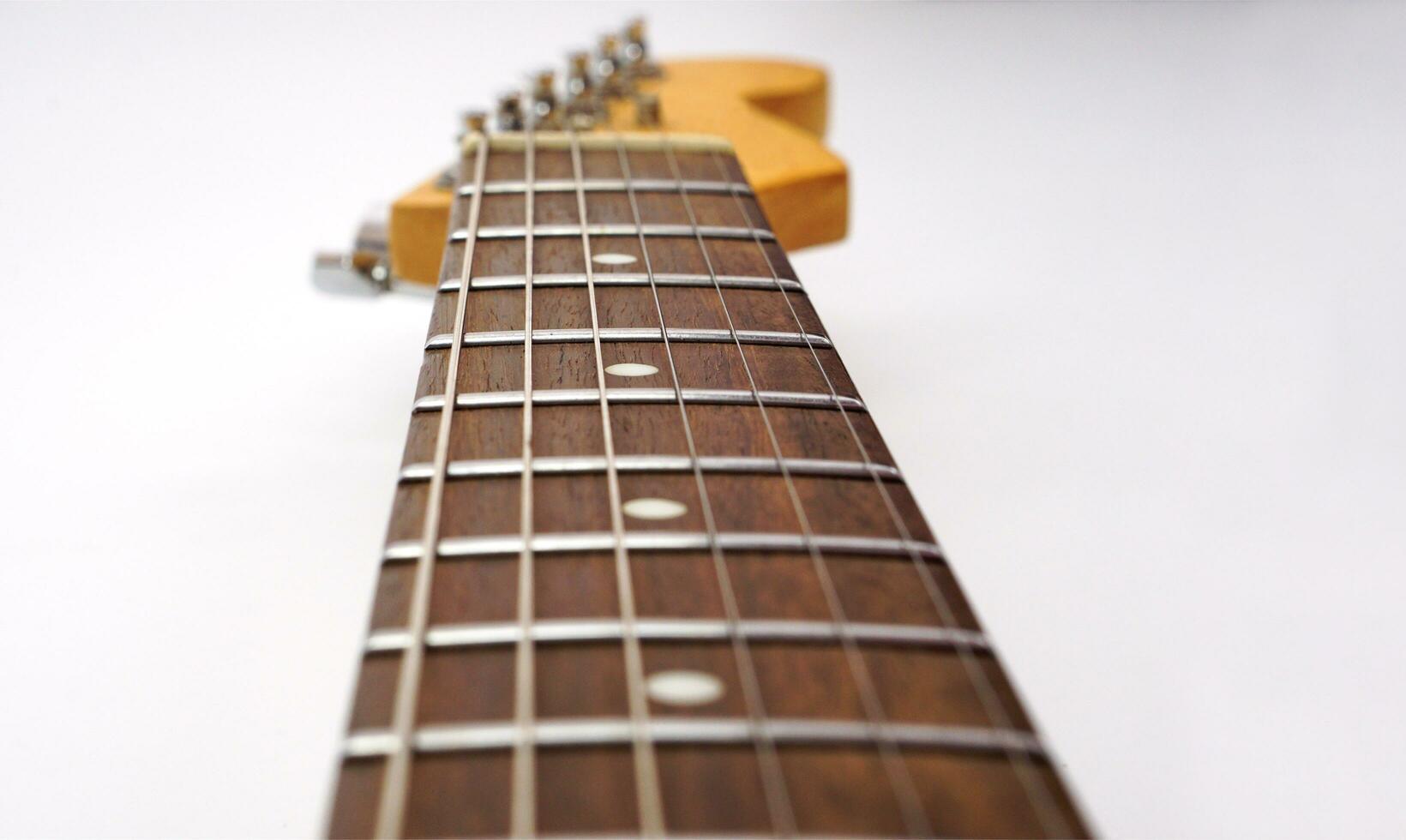 Selective focus, electric guitar neck on white background with copy space. Love, entertainment and music concept. photo