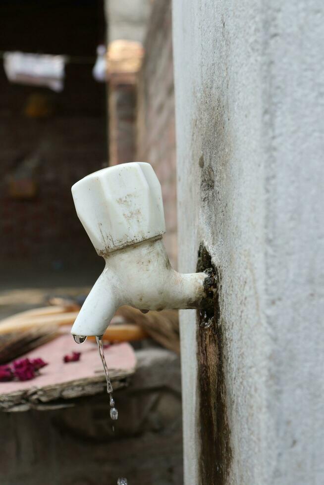water coming out of plastic tap. save water, water is life photo