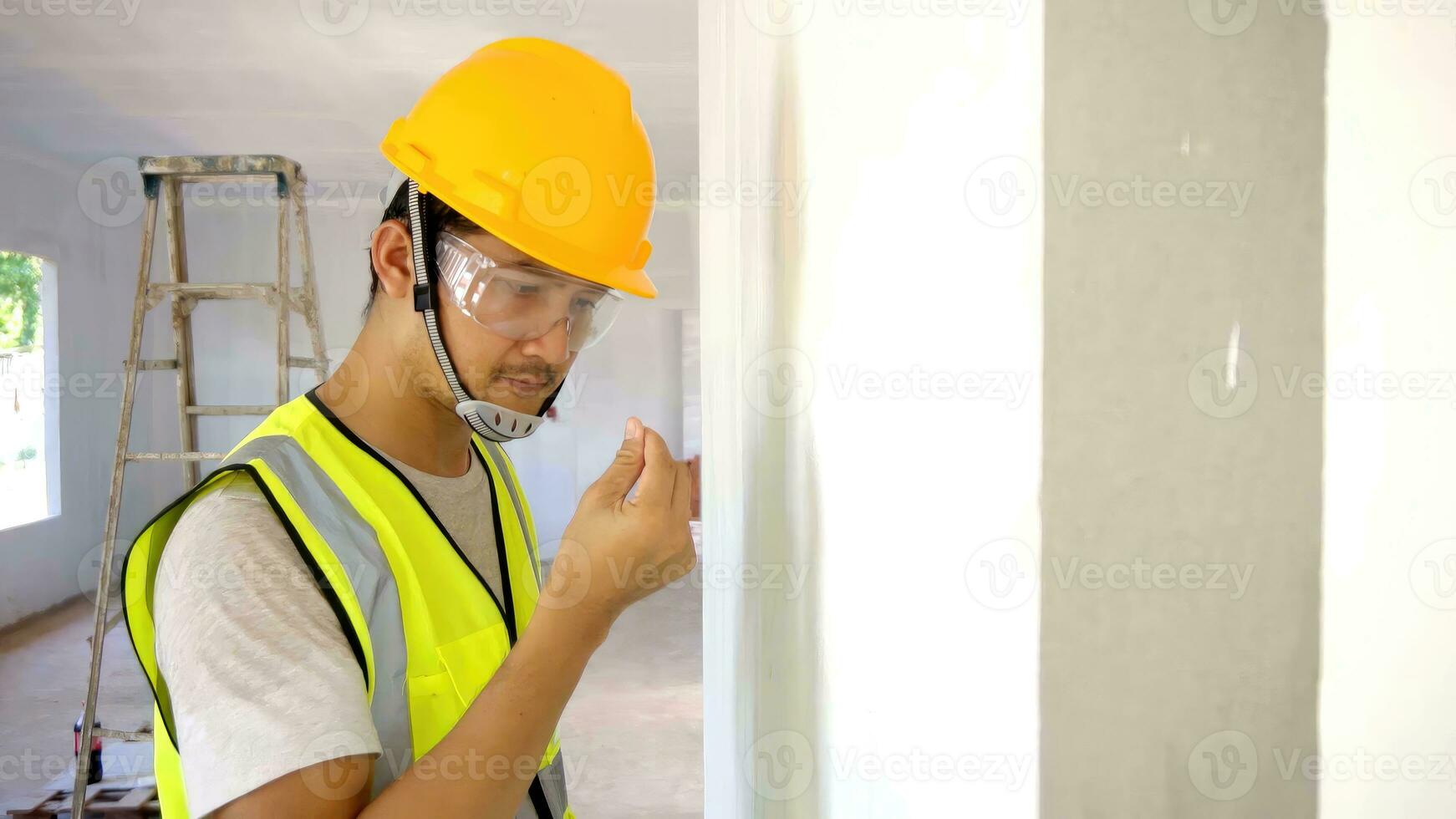 The foreman is checking the color consistency of the walls, looked from the side and touched professionally. photo