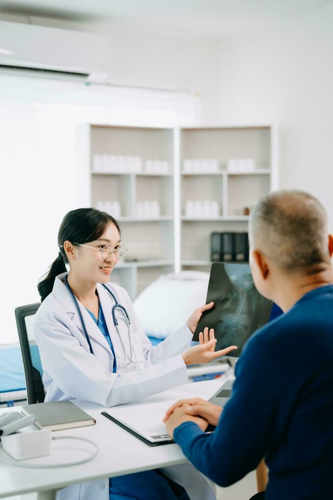 Serious Asia female doctor using clipboard is delivering great news talk discuss results or symptoms with female patient in clinic or hospital photo