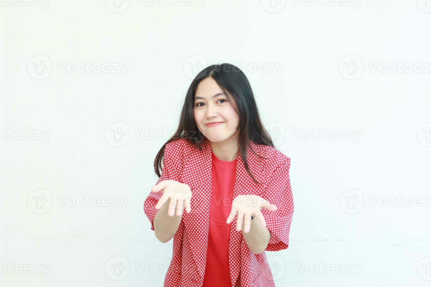 portrait of beautiful asian woman wearing red outfit with hand gesture presenting something or copy space photo