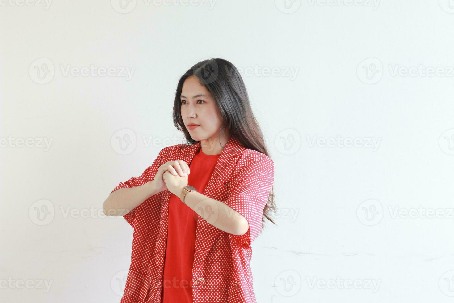 portrait of beautiful asian woman wearing red outfit with fist gesturing with serious expression photo