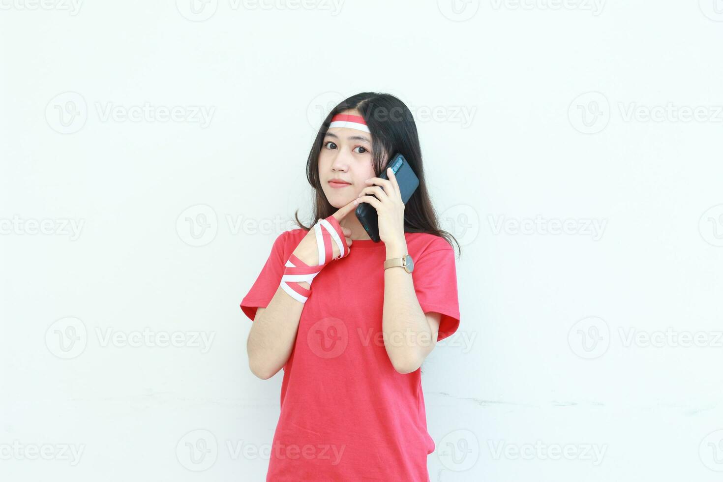 portrait of beautiful asian woman wearing red outfit celebrating Indonesia independence day while calling with a thinking expression photo