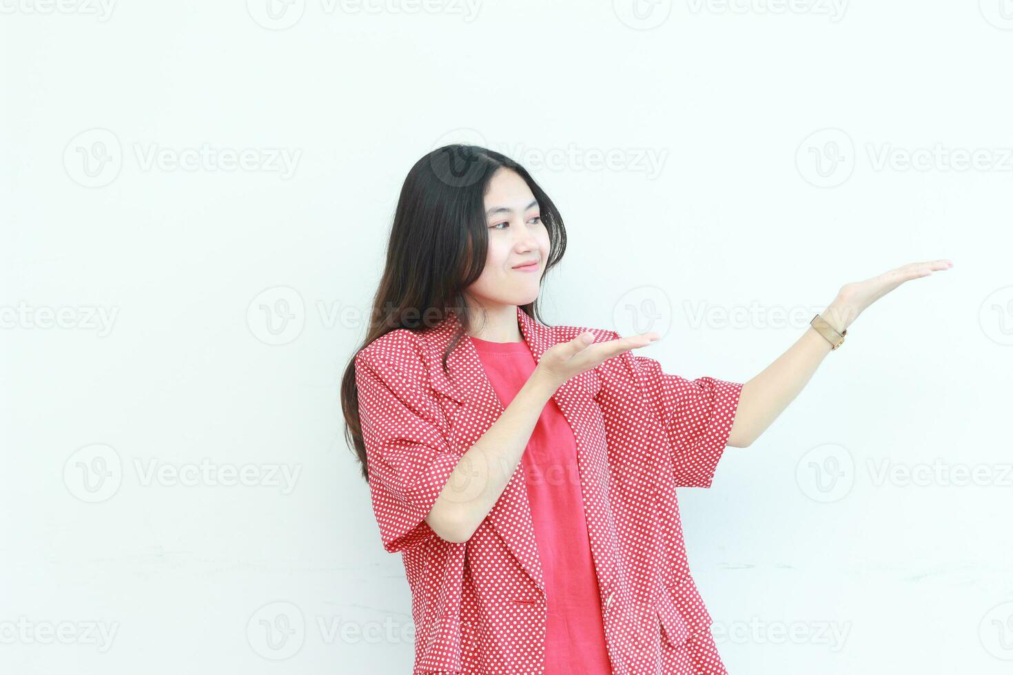 portrait of beautiful asian woman wearing red outfit pointing to the side for copy space photo