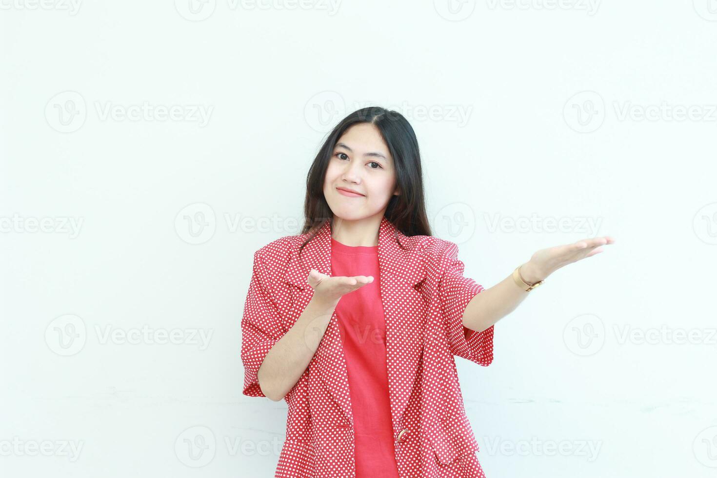 portrait of beautiful asian woman wearing red outfit pointing to the side for copy space photo