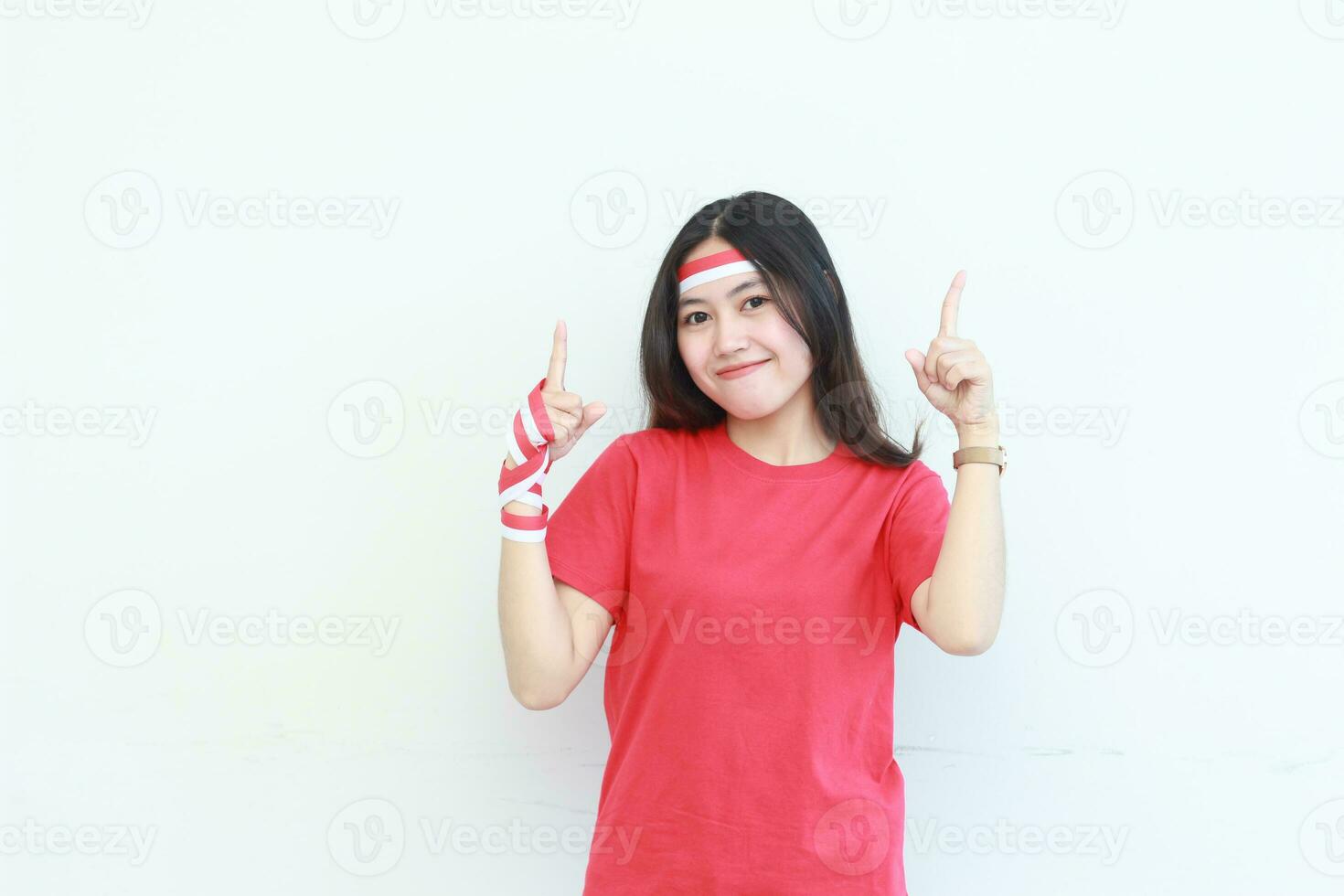 retrato de hermosa asiático mujer vistiendo rojo atuendo celebrando Indonesia independencia día señalando arriba para Copiar espacio foto