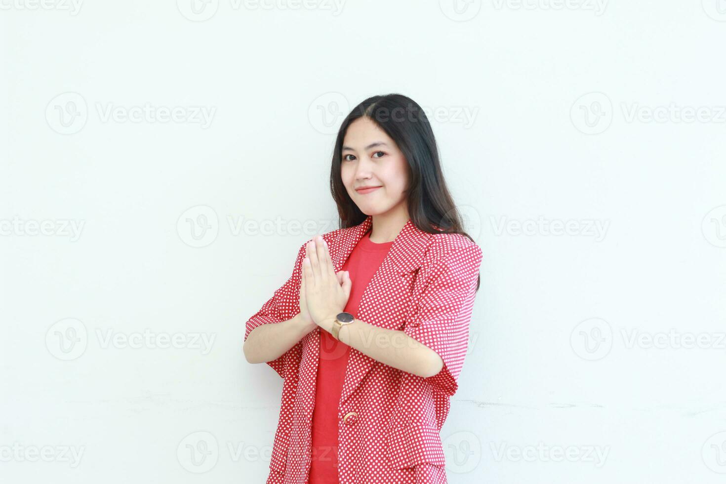 portrait of beautiful asian woman wearing red outfit with namaste gesture while smiling photo