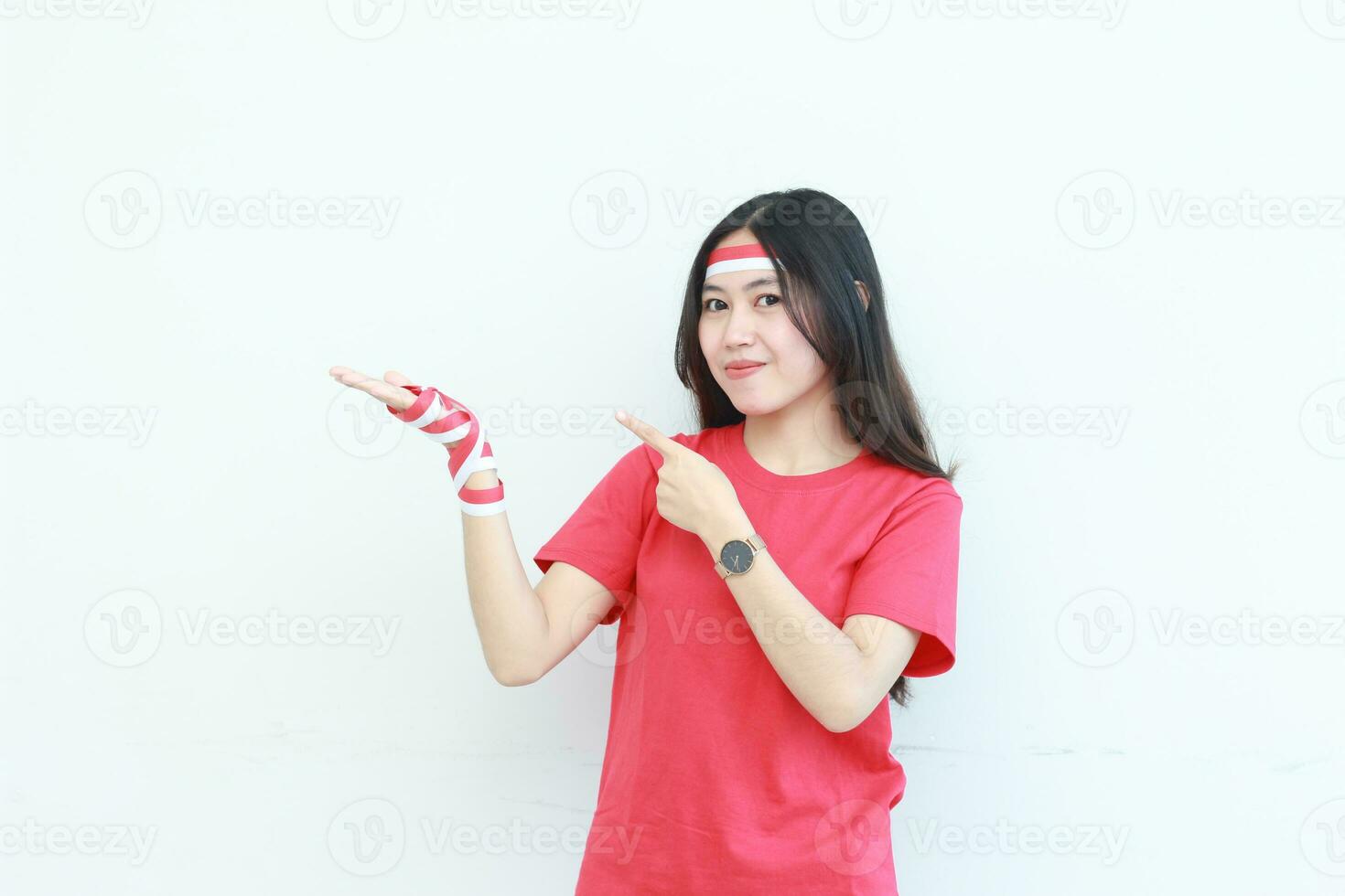 portrait of beautiful asian woman wearing red outfit celebrating Indonesia independence day pointing to the side for copy space photo