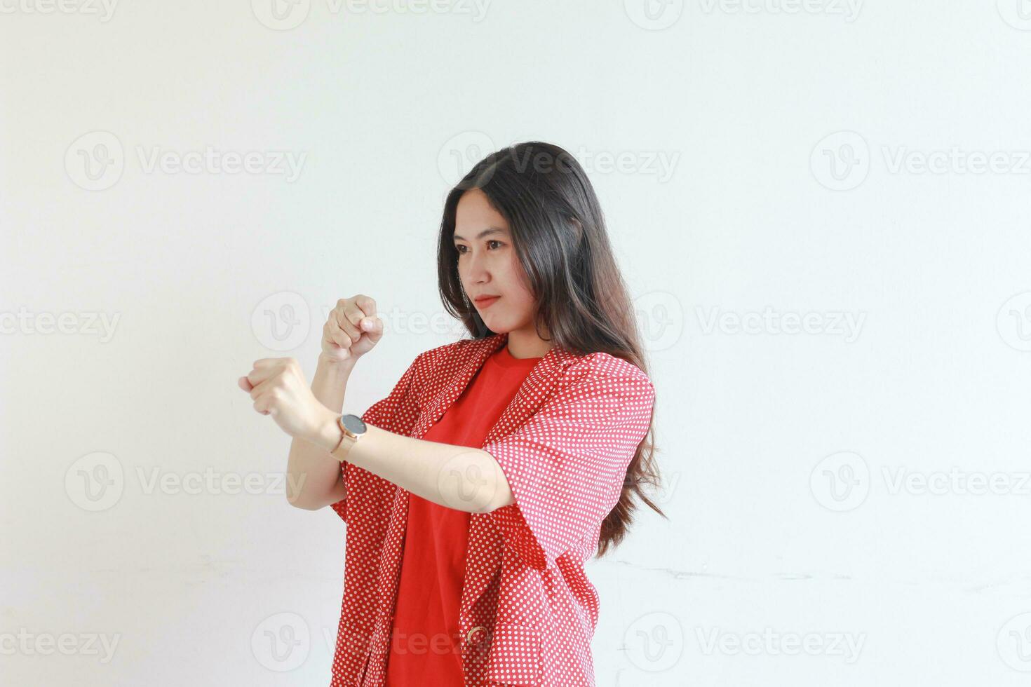 portrait of beautiful asian woman wearing red outfit with fist gesturing with serious expression photo