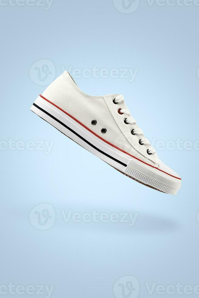 White female stylish sneakers on blue background photo