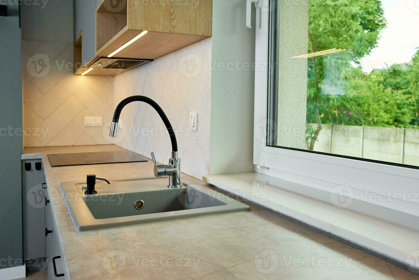Interior of a modern kitchen with sink near window photo