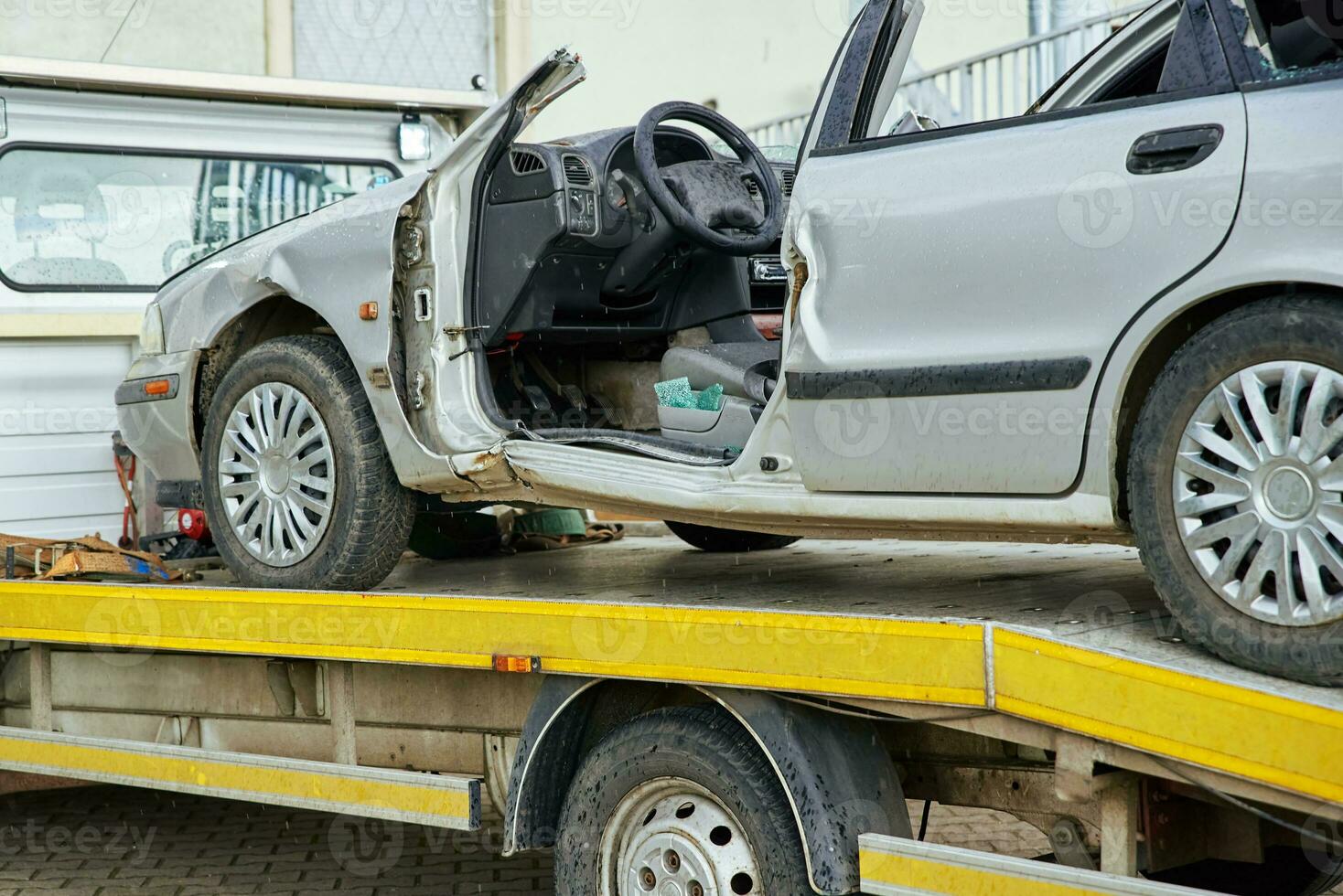 Crashed car loading into tow truck after traffic accident on road photo