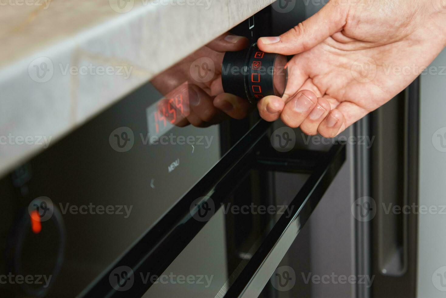 Female choosing program on electric oven panel photo