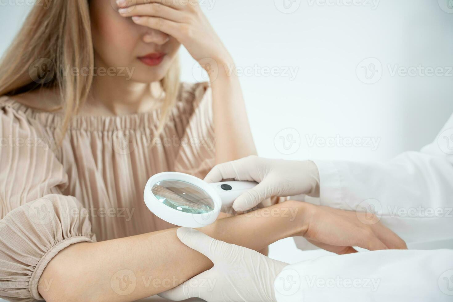 skin problem and beauty of asian girl. Dermatologist use magnifying glass look itchy skin from skin allergic, steroid allergy, sensitive skin, chemical allergy, rash, insect bites, Dermatitis. photo