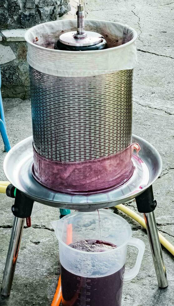 The process of making homemade grape wine. The operation of a hydraulic press to obtain grape juice for fermentation. photo