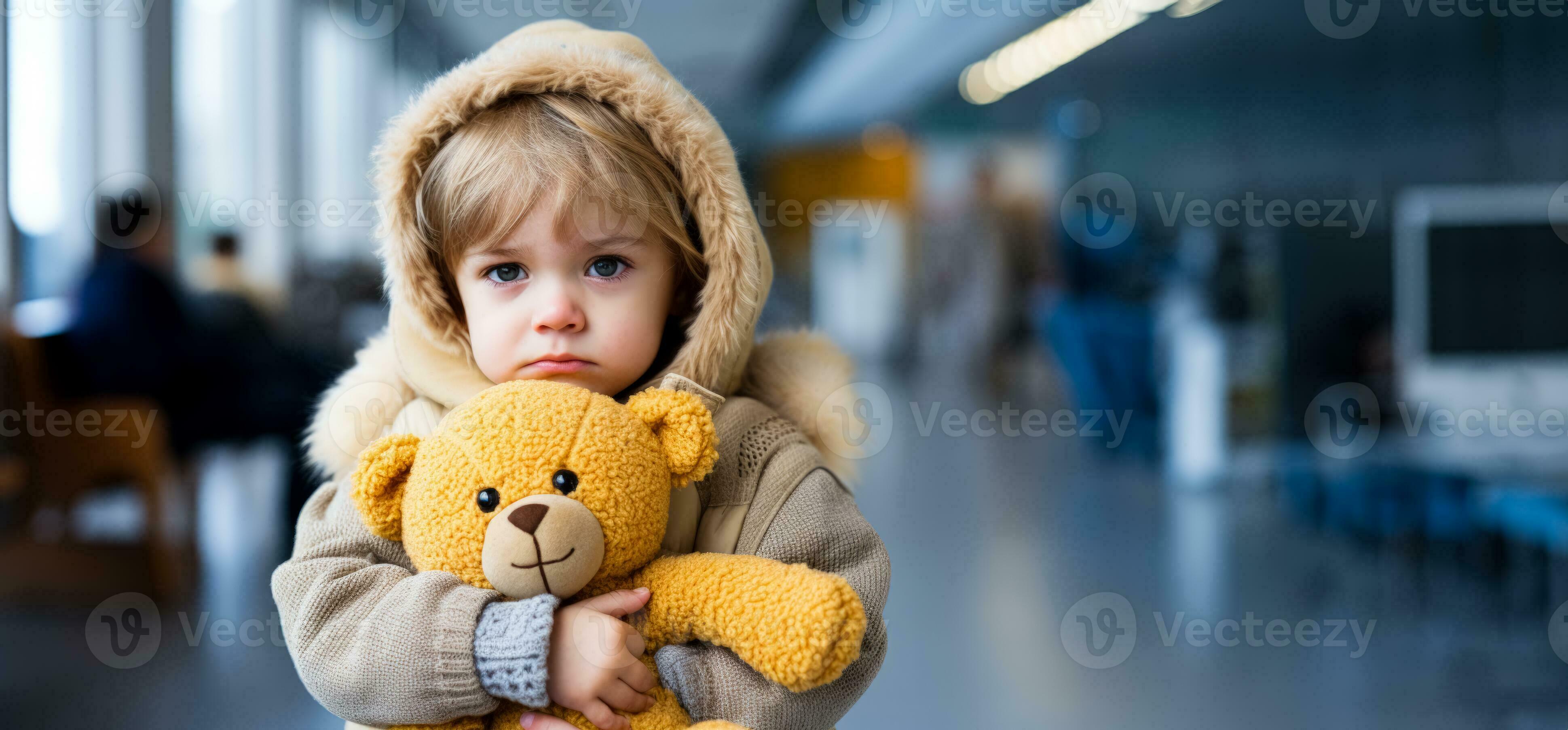 A child clutching a comfort toy tightly isolated on a blue gradient A child clutching a comfort toy tightly isolated on a blue gradient