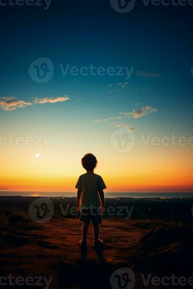 A child gazing at the horizon isolated on a dusk gradient background photo