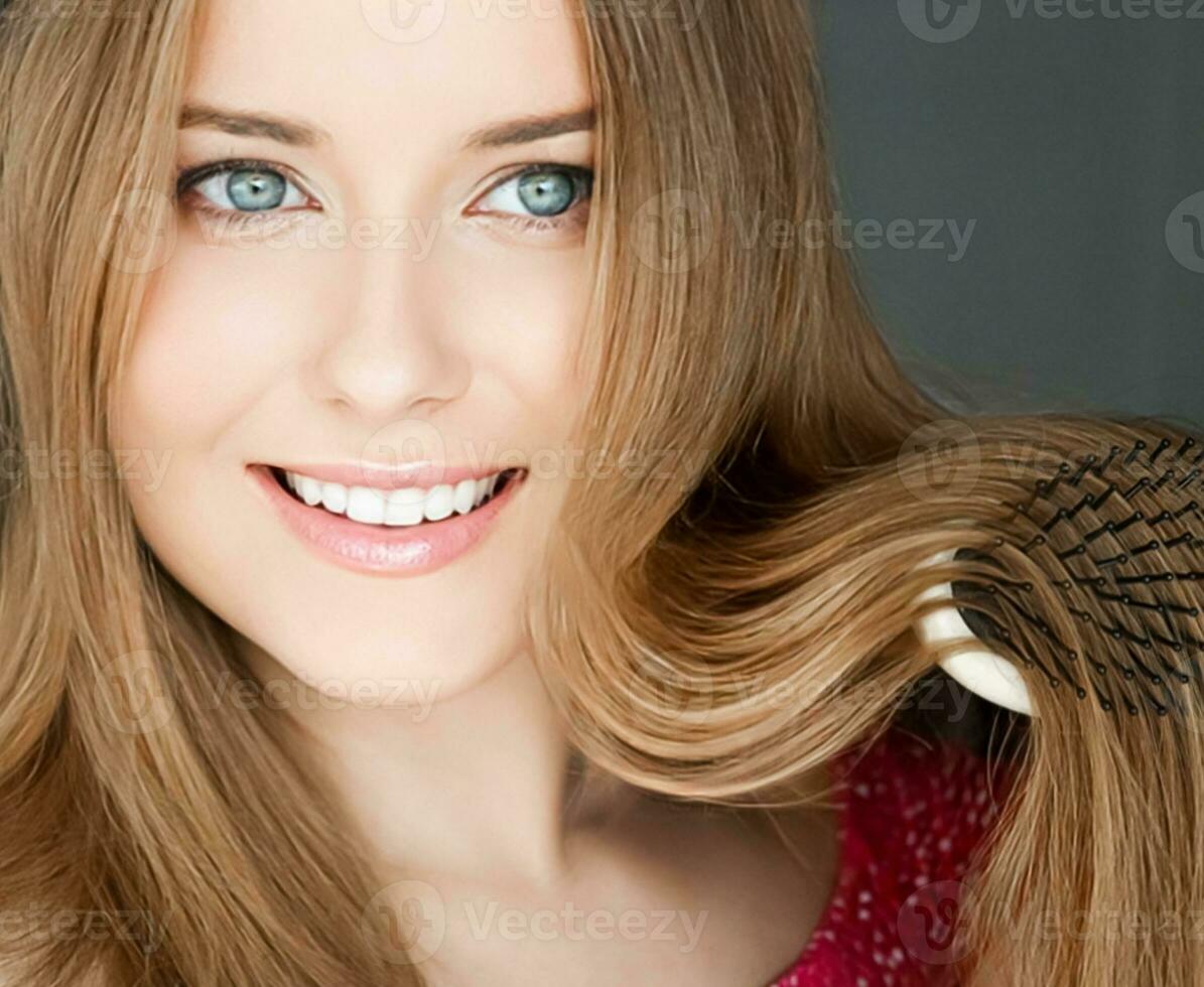 Beautiful happy woman combing her long hair photo