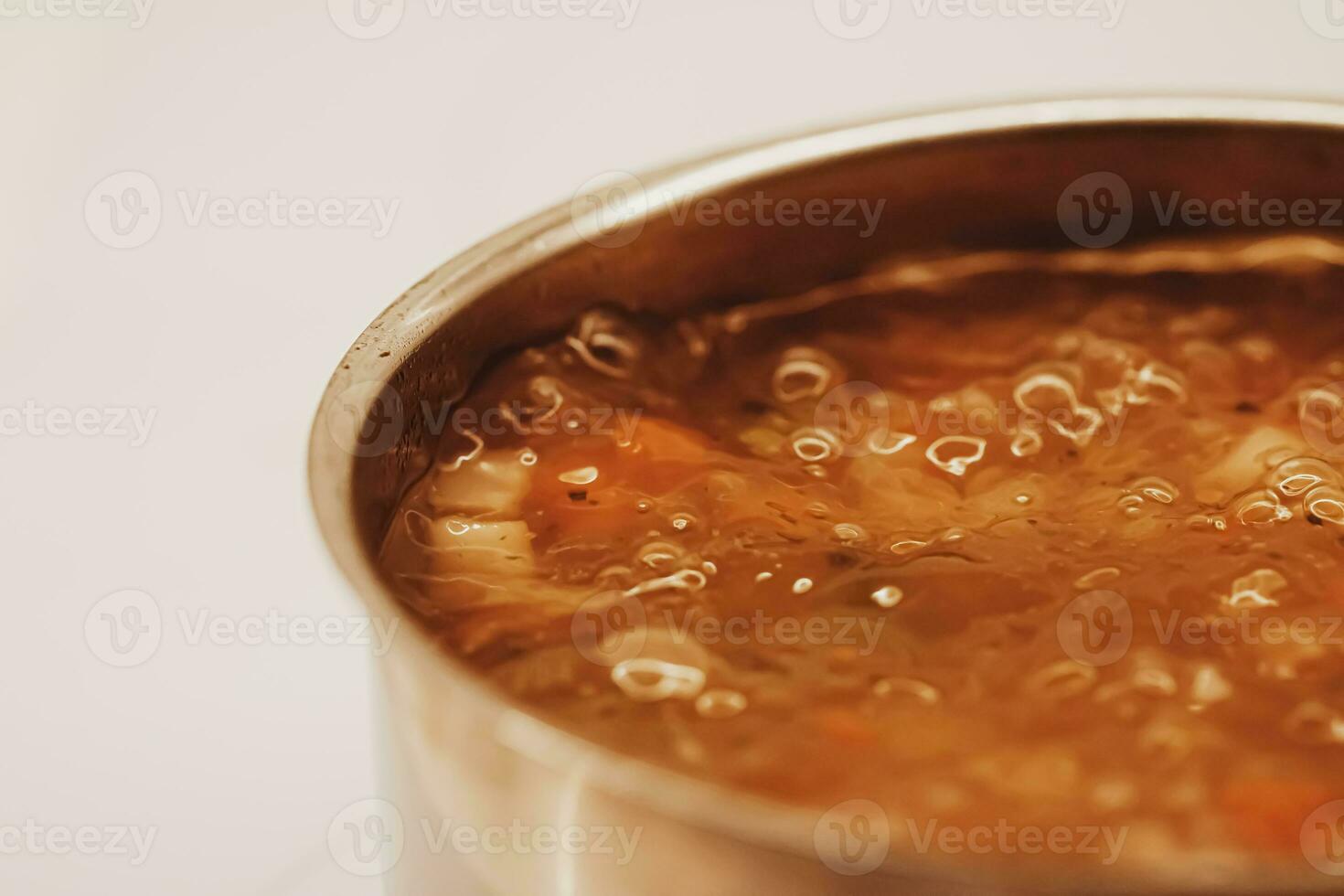 Vegetable soup with beans boiling in a saucepan, homemade food photo