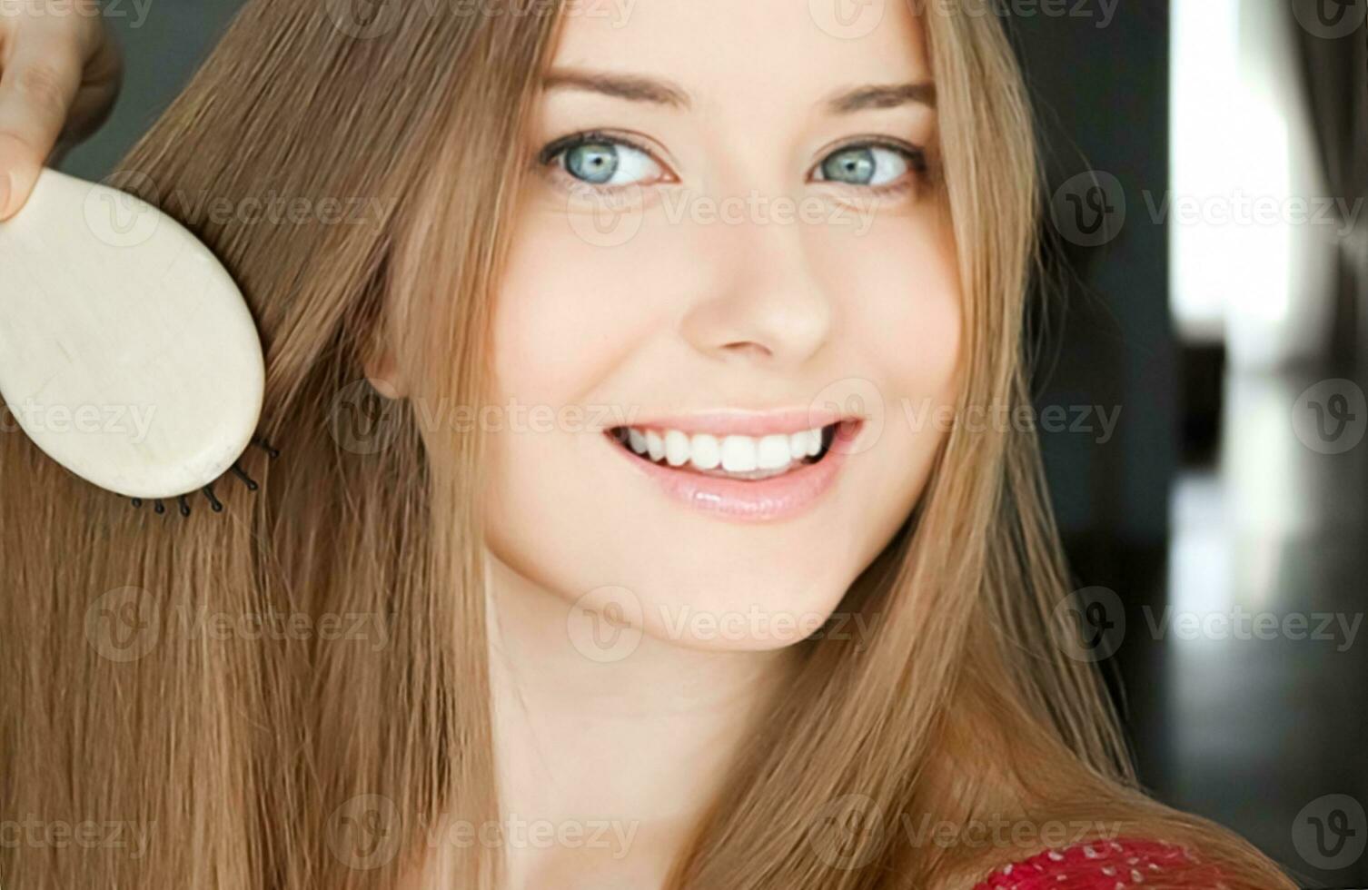 Beautiful happy woman combing her long hair photo