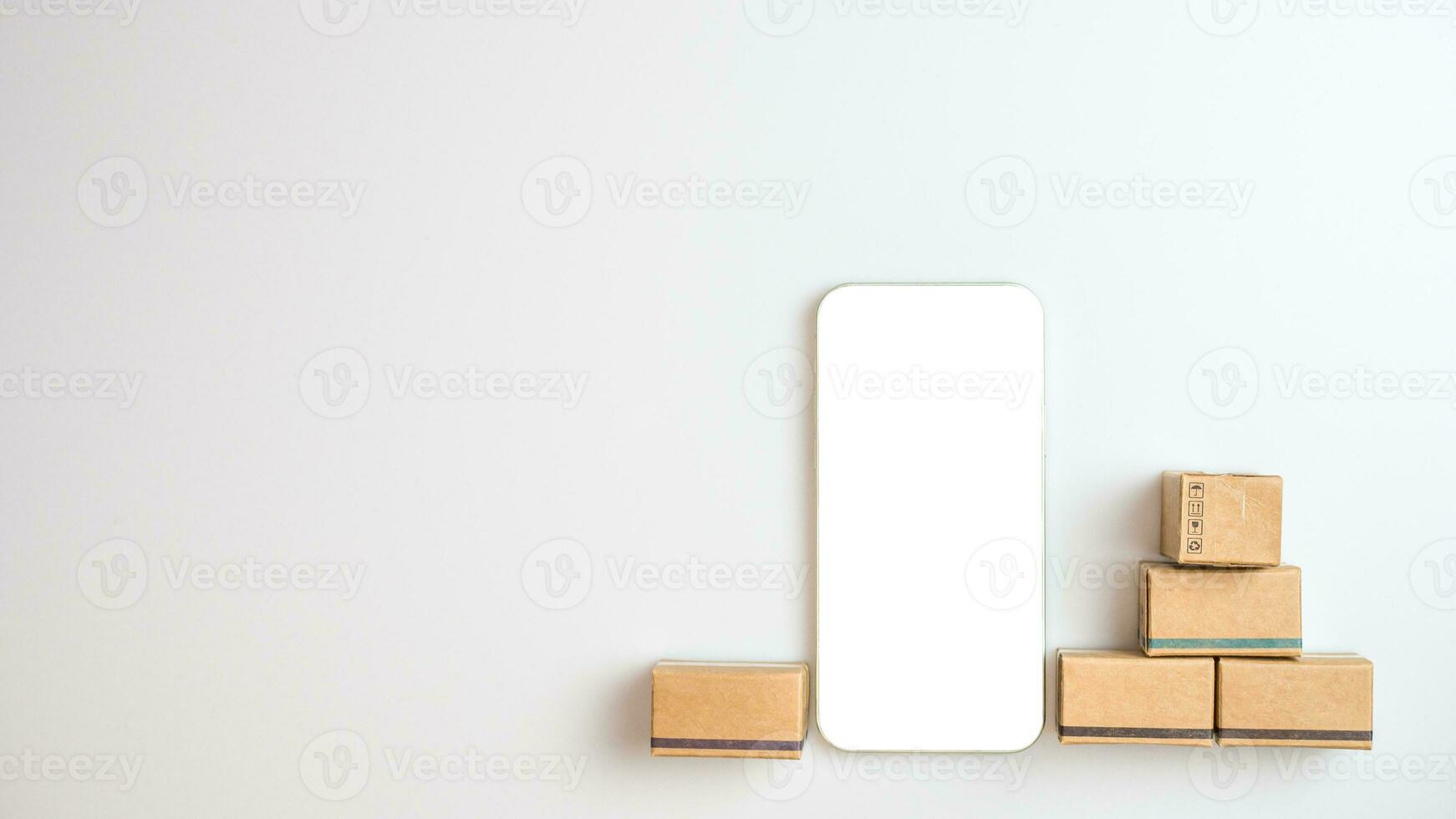 Shopping concept. Cardboard box and phone with blank screen on white background. Online shopping consumers can choose from home shopping and delivery services. with copy space. photo