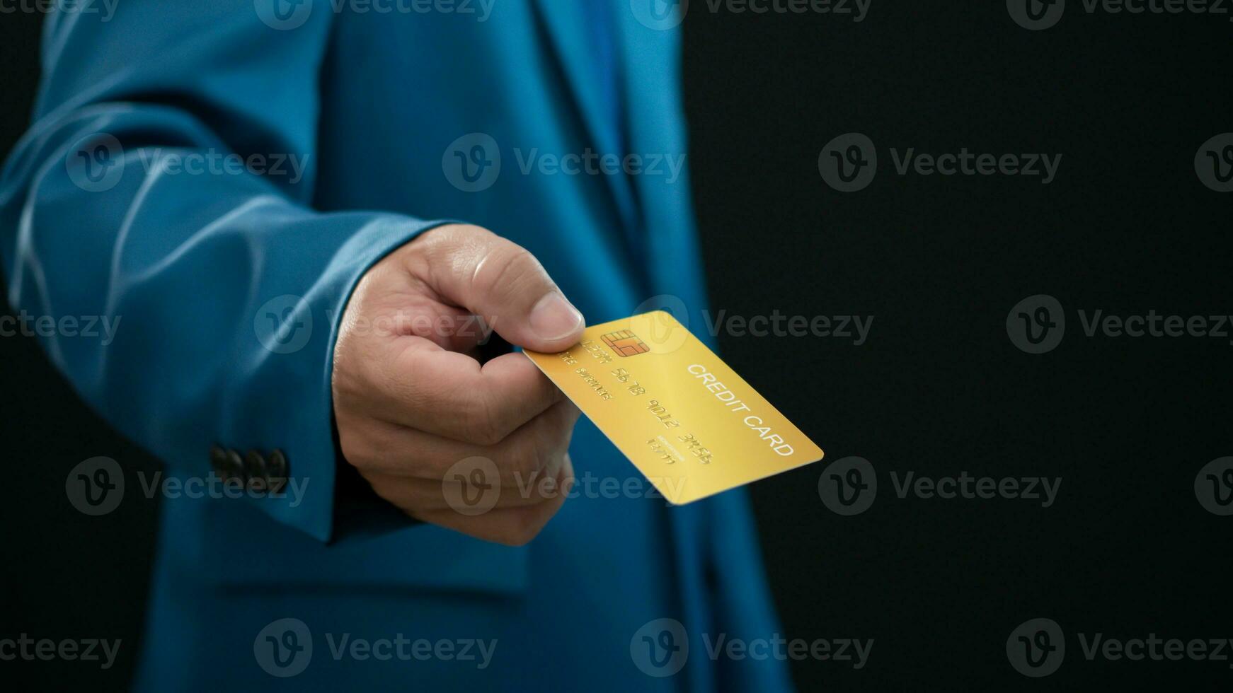 Businessman holding credit card on dark background. Shopping concept. Cashless spending concept. loan concept photo