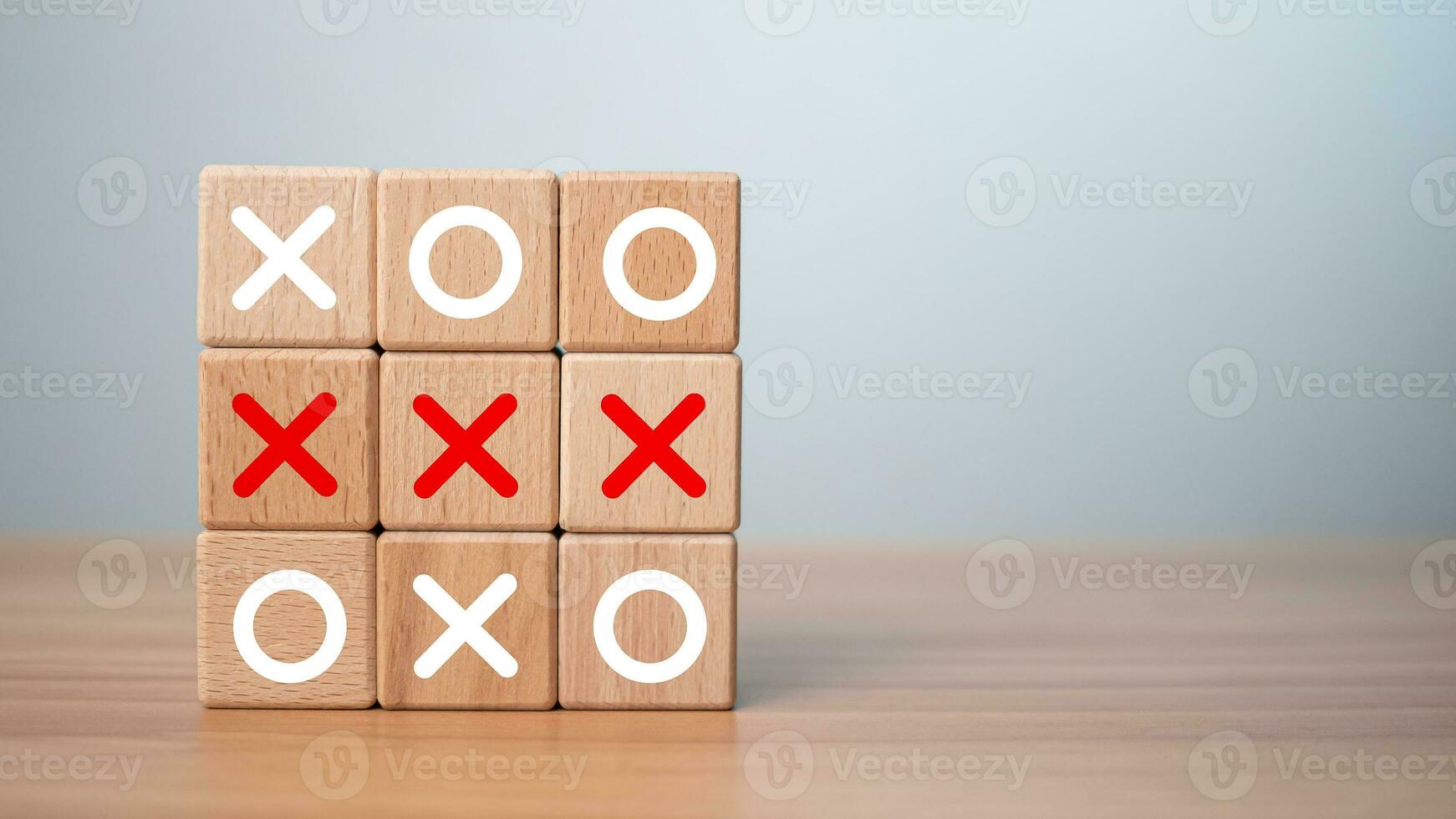 Tic Tac Toe game made of wooden blocks. Front view of wooden OX game on wooden table.Business marketing strategy planning concept. Business competitor assessment concept. photo