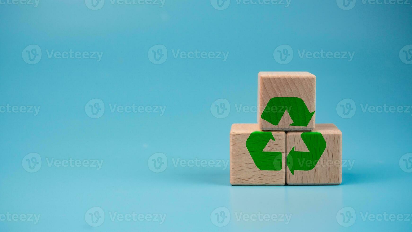 Stacked wooden blocks with green recycle symbol. Recycling concept. photo