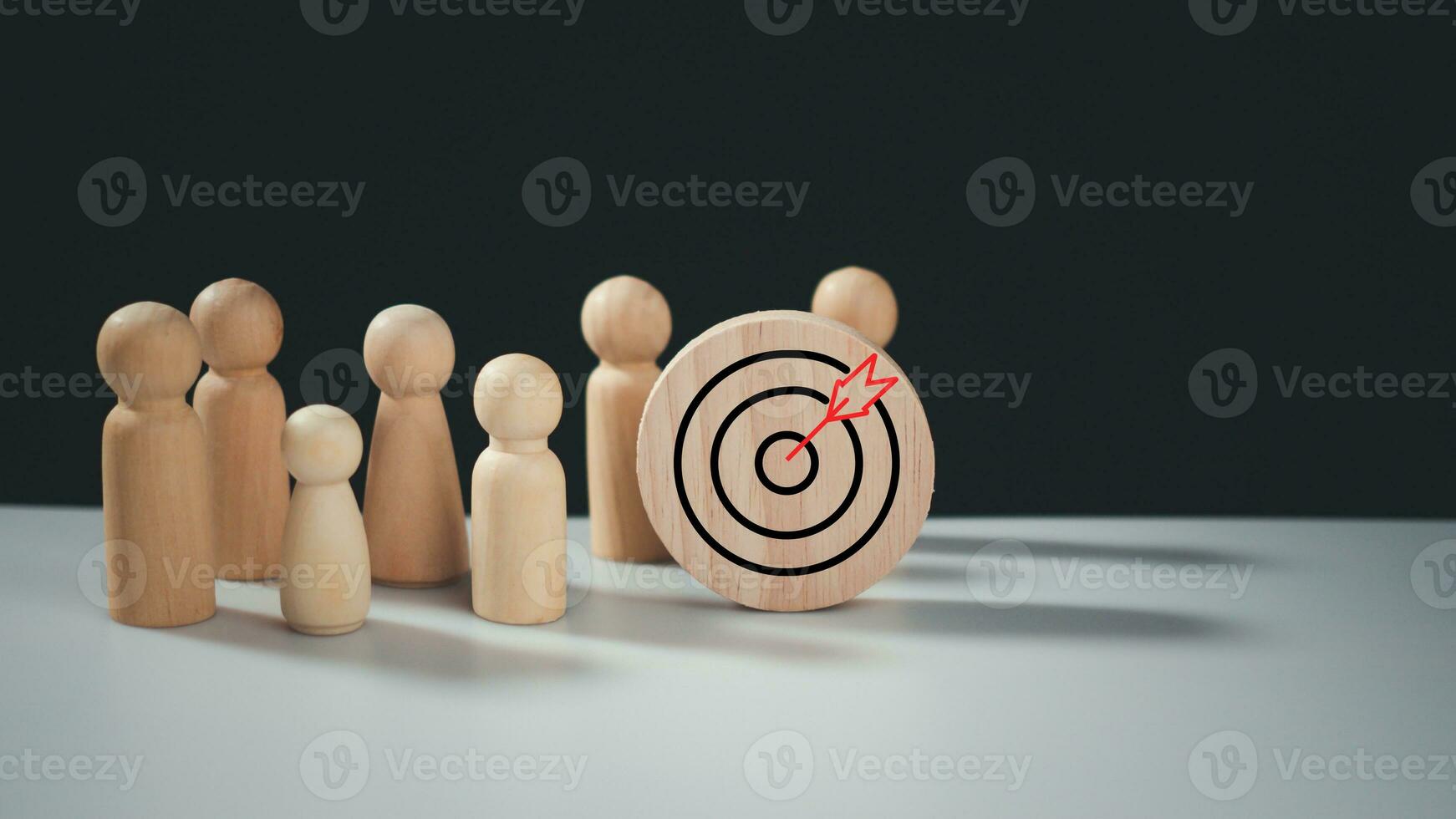 Target concept of business and personnel in a company. wooden dolls standing around Dart board and arrows for creating and targeting business objectives. Marketing solutions. photo