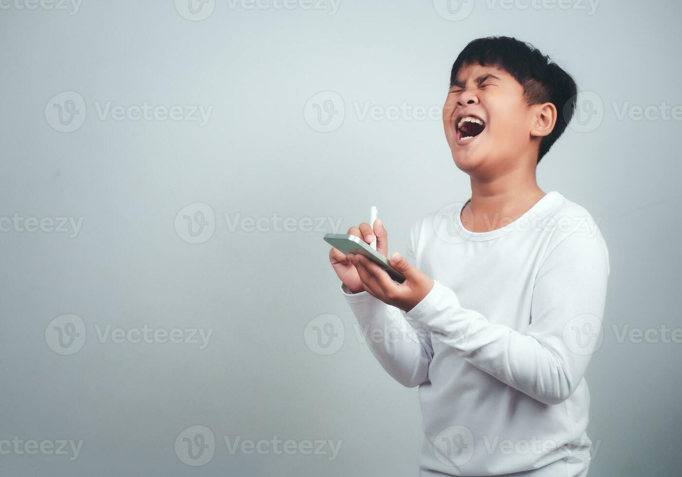 Social media and technology concepts. Boy's hands holding a smartphone and stylus pencil to use multimedia and social media to communicate. photo